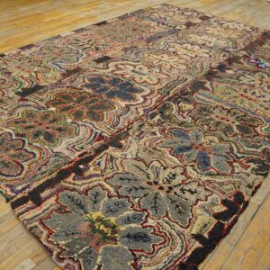 Textured multicolored rug displaying large stylized floral patterns on light wood plank flooring.