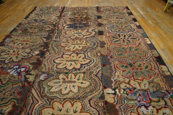 High-texture, multicolored floral and wavy patterned rug displayed on yellow wooden floorboards.
