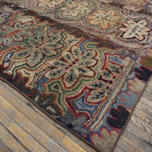 Intricate red, blue, green, and gray hooked rug featuring large floral medallions on worn wood floors.