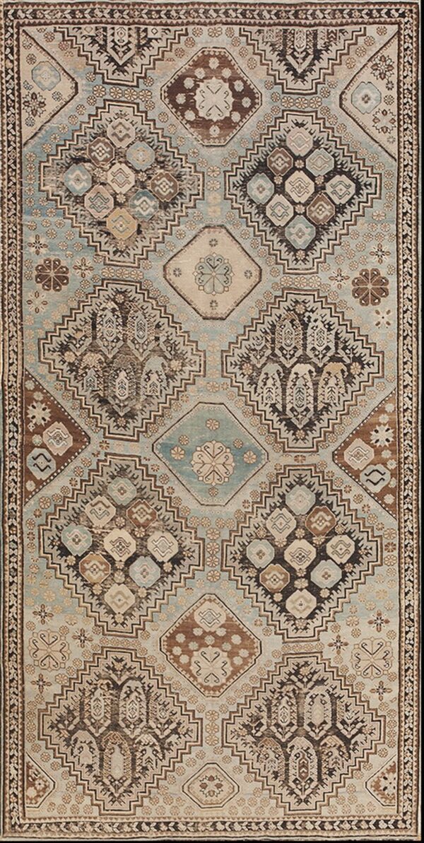 Low-pile geometric rug in light blue, brown, and beige with a distressed tribal pattern.