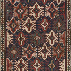 Geometric flat woven rug displaying repeating patterns in navy blue, rusty red, cream, and teal accents.