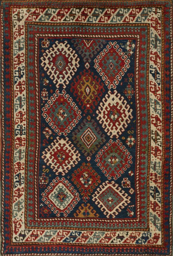 Low-pile rug with a deep navy field and dense tribal patterns in red, cream, and slate blue.