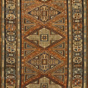 Geometric flatweave runner featuring interlocking diamond motifs in orange, blue, and natural tan colors.