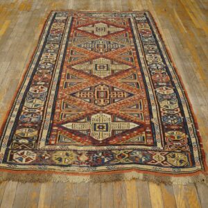 Geometric runner rug featuring intricate designs in terracotta, navy, and cream on rustic wooden floorboards.