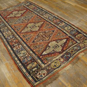 A geometric rug featuring rust, blue, and cream patterns lies on rustic wooden flooring.