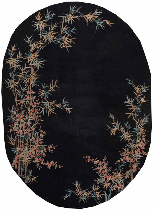 Black oval rug featuring asymmetric botanical pattern of tan and teal bamboo and coral flowers.
