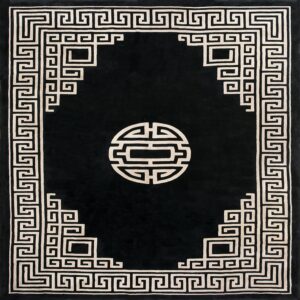 Black rug with a light geometric border, interlocking key pattern, and a circular center design.
