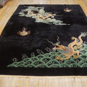Dark plush rug featuring two golden dragons and green waves laid out on wood flooring.