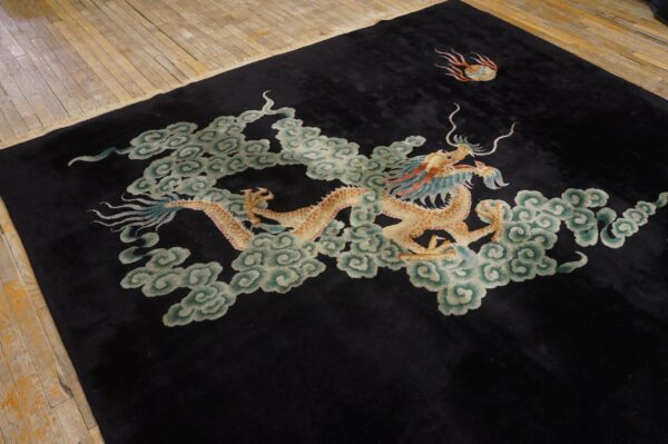 Medium pile black rug with a golden dragon and blue-green clouds on rustic hardwood flooring.
