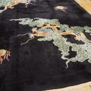 Velvety black rug featuring large gold dragons and pale green cloud motifs on wood planks.