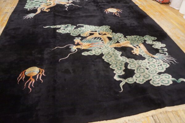 Velvety black rug featuring large gold dragons and pale green cloud motifs on wood planks.