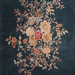 A dark teal rug features a large, central spray of pink, cream, and gold flowers and intertwining branches.