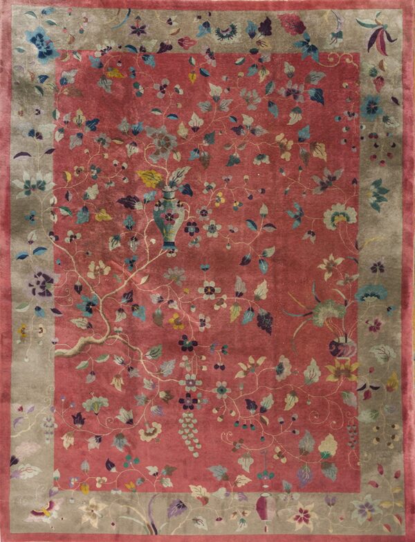 Low-pile rug with a lustrous dusty rose field and taupe border, covered in multicolored floral motifs.