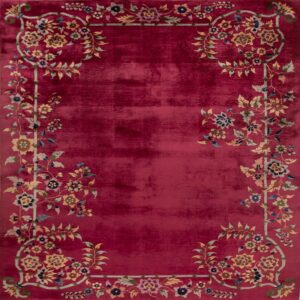 Saturated red rug with a prominent border of multicolor vines, flowers, and leaves.