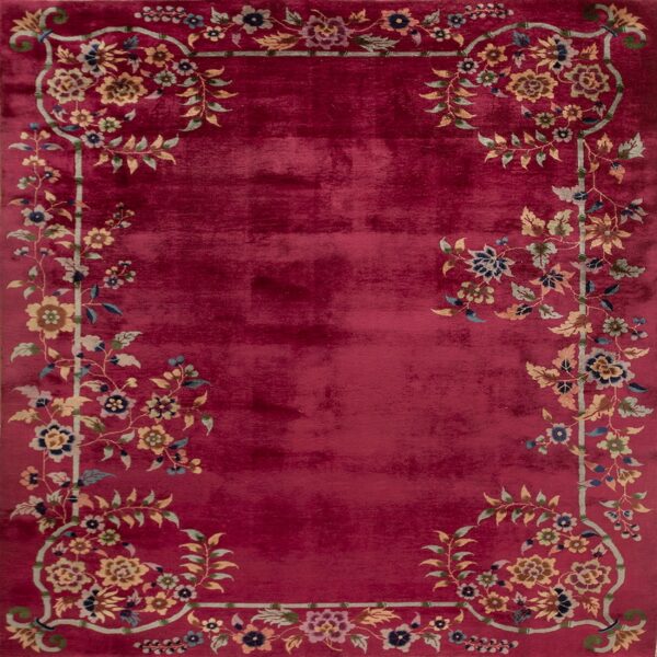 Saturated red rug with a prominent border of multicolor vines, flowers, and leaves.