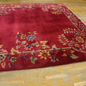 High-pile magenta rug featuring a detailed multicolored floral border on a rustic wooden floor.