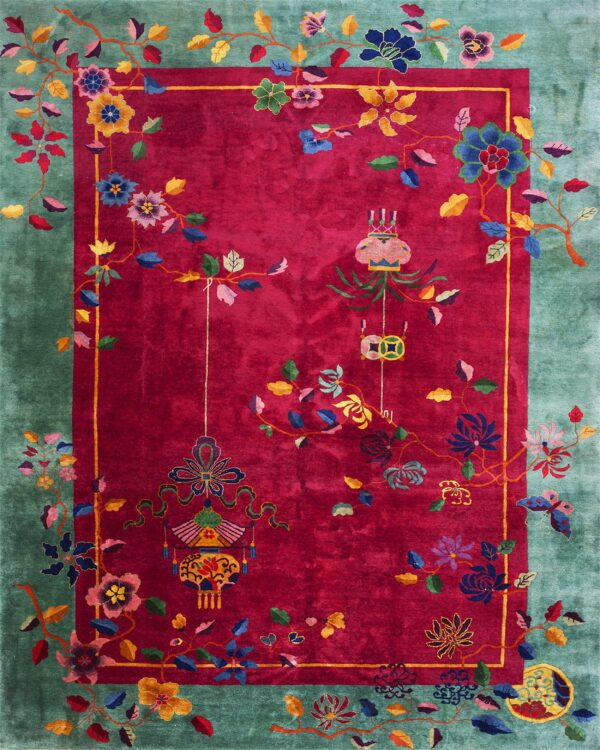 A velvety magenta rug featuring a colorful vine, flower, and lantern pattern within a teal border.