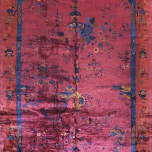 Deep magenta rug featuring a sprawling blue and yellow botanical pattern framed by contrasting red borders.