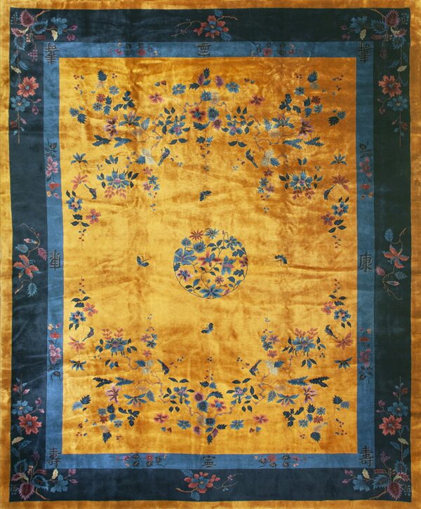 Reflective gold rug with a dark border, featuring sprawling blue, pink, and mauve floral vine patterns.