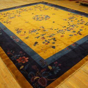 Yellow high-pile rug with navy and teal borders, featuring scattered florals on a distressed wooden floor.