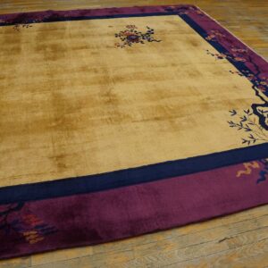 Yellow gold rug with magenta and navy borders featuring Chinoiserie floral patterns on wood flooring.