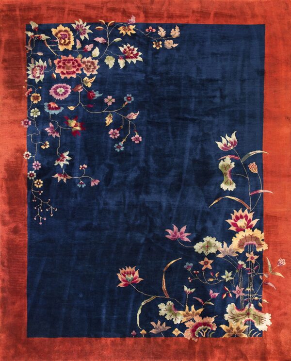 Deep blue rug featuring a vibrant multicolored floral vine design and a wide reddish-orange border.