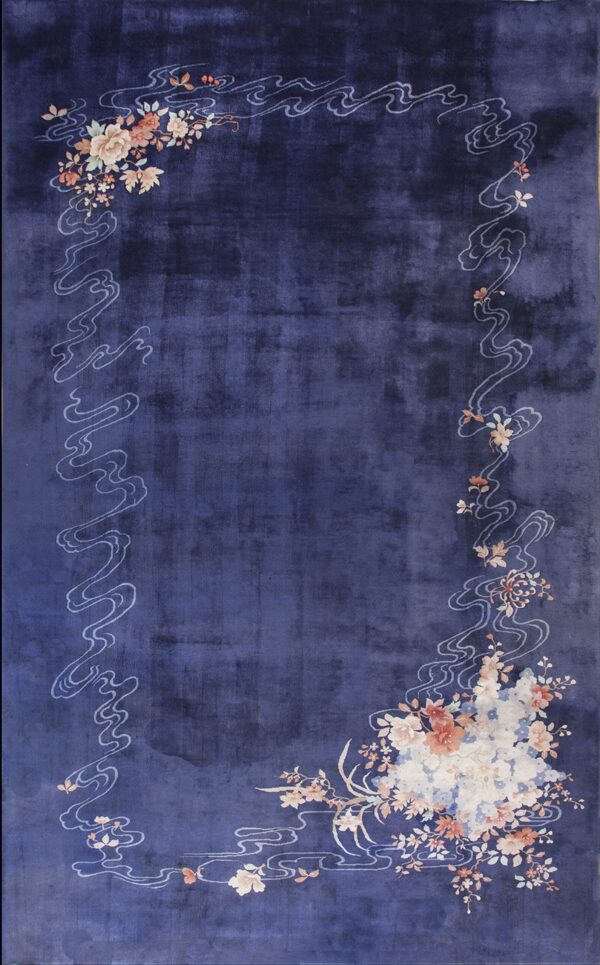 Indigo rug with an ornate border of light blue clouds and multicolored flowers in the corners.
