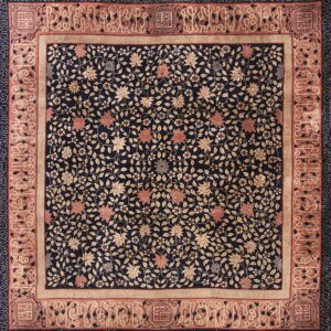 Dark navy rug covered in dense tan and salmon vines and flowers, surrounded by detailed terracotta borders.