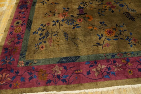 Olive green rug with a colorful floral vine design is framed by magenta and teal patterned borders.