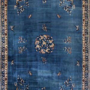 Teal-blue rug with abrash, featuring corner dragons, butterflies, a central medallion, and cream detailed borders.