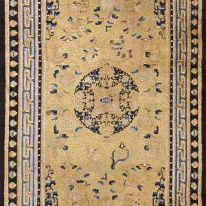 Rectangular golden beige rug with dark blue stylized floral patterns and a wide geometric border.