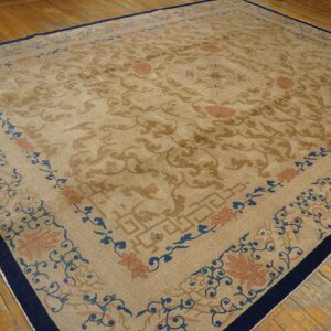 Beige and brown traditional rug with blue and terracotta borders resting on distressed hardwood.