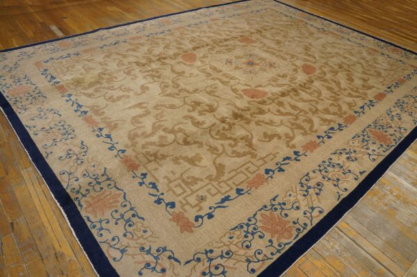 Beige and brown traditional rug with blue and terracotta borders resting on distressed hardwood.