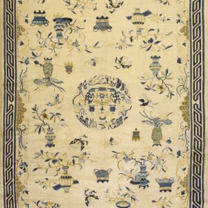 Cream rug with a wide blue geometric border and scattered blue and gold vases and floral motifs.