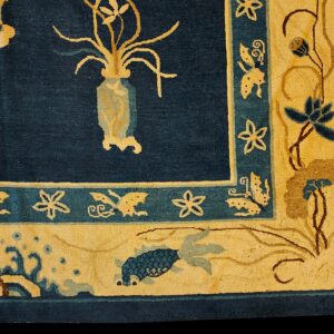 Navy blue rug corner detail shows golden floral, fish, and butterfly patterns on a wide gold border.