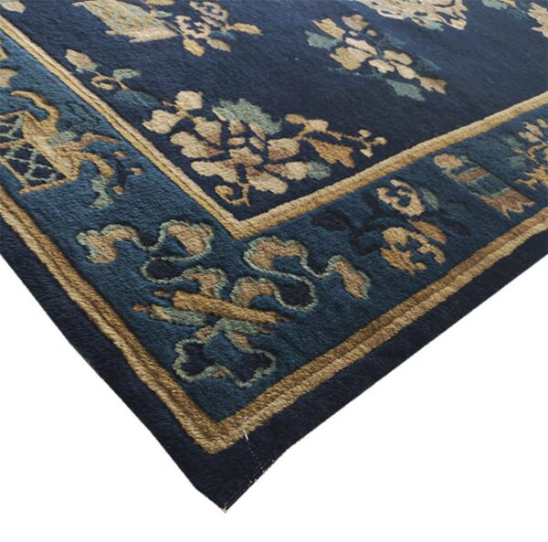 Antique peking small scatter size wool navy rug 5 Close up of a dark blue rug corner featuring tan and teal botanical patterns and a multi-layered border.