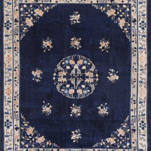 Deep blue rug with an ornate ivory and peach floral pattern, including a central medallion.