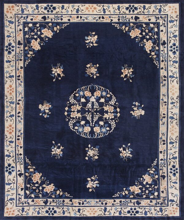 Deep blue rug with an ornate ivory and peach floral pattern, including a central medallion.