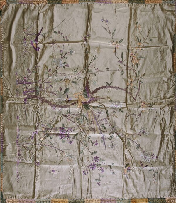 Square, wrinkled taupe textile with intricate purple, tan, and green embroidery of birds and flowers.
