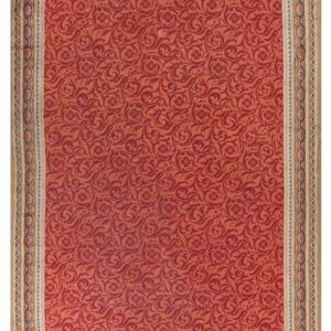 Red rug featuring a scrolling damask pattern and a wide beige border with blue and salmon chain links.