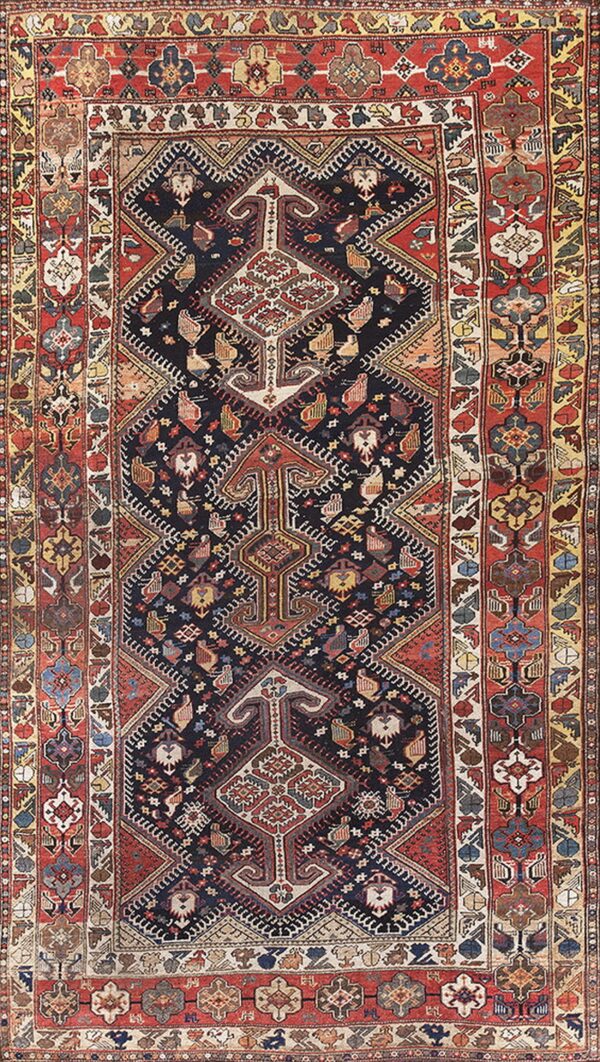 A detailed tribal rug with a navy blue field and complex stylized patterns, framed by thick red and gold borders.