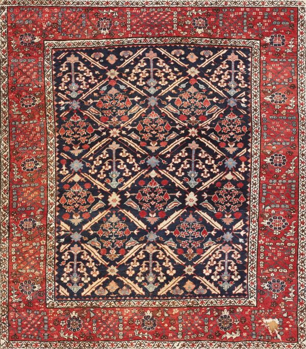 Traditional navy and red rug features a detailed lattice pattern with floral motifs, showing visible wear and damage on the border.