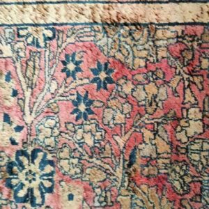 Intricate woven detail showing dark blue, dusty rose, and tan colors in a traditional floral motif.