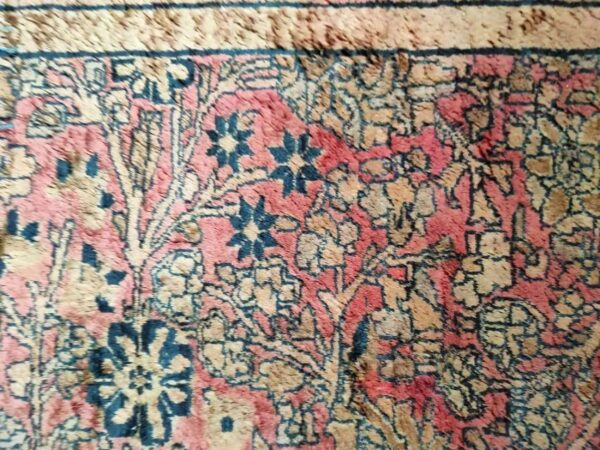 Intricate woven detail showing dark blue, dusty rose, and tan colors in a traditional floral motif.