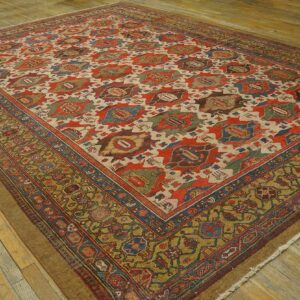 Large rug displaying red and cream geometric medallions bordered by intricate olive green designs on wood.