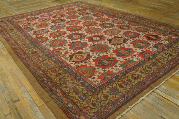 Large rug displaying red and cream geometric medallions bordered by intricate olive green designs on wood.
