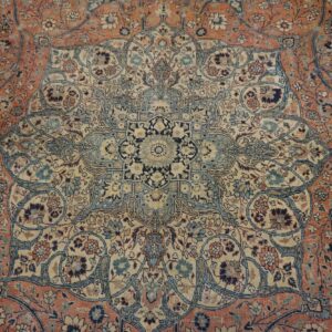 Ornate rug detail showing a central medallion and field patterned with dusty blue, rust, and cream florals.