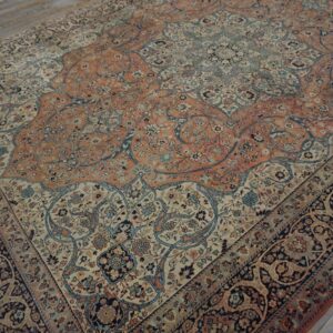Intricate low-pile rug in terracotta, navy, and cream floral patterns rests on weathered wood planks.