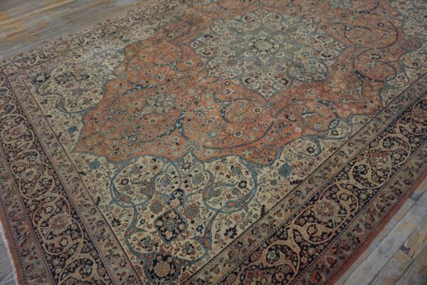Intricate low-pile rug in terracotta, navy, and cream floral patterns rests on weathered wood planks.