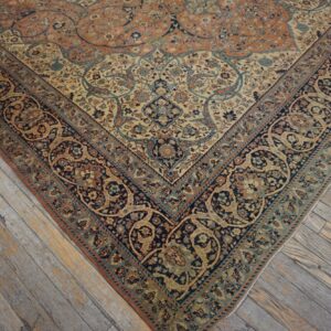Ornate navy, cream, and rust traditional rug rests on distressed gray hardwood flooring.